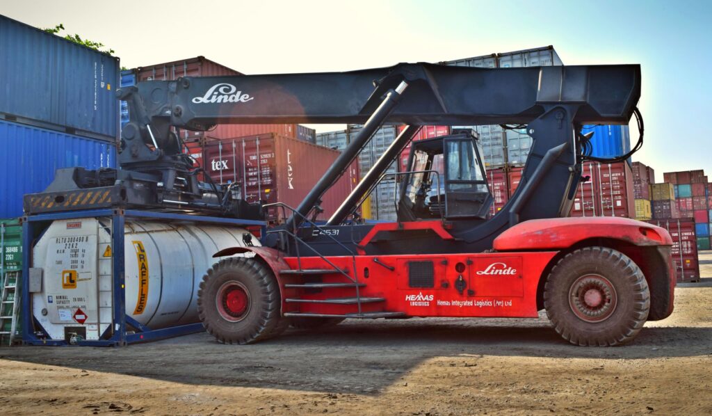 Forklift operating at a cargo yard, moving large containers efficiently. — ventajas y modelos destacados